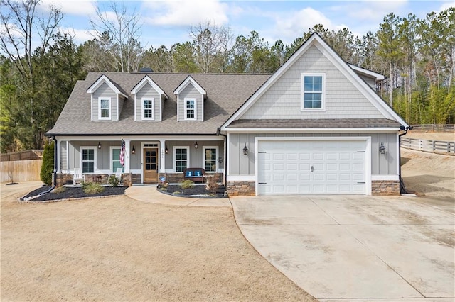 view of front facade featuring driveway, a porch, board and batten siding, and fence