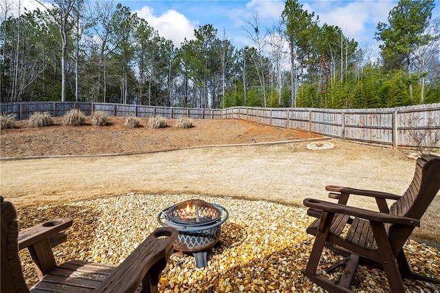 surrounding community featuring a fenced backyard and a fire pit