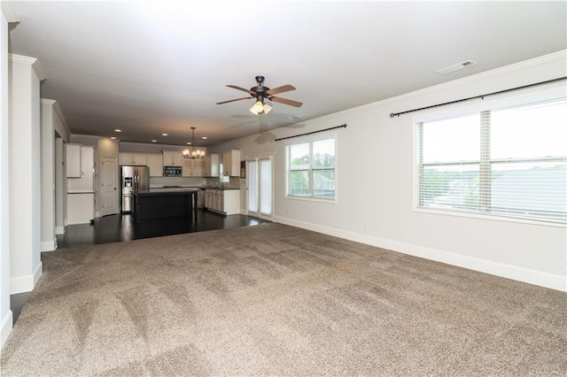 626 Discovery Ct, Acworth, GA 30102 - unfurnished living room with baseboards, visible vents, ceiling fan with notable chandelier, and dark colored carpet