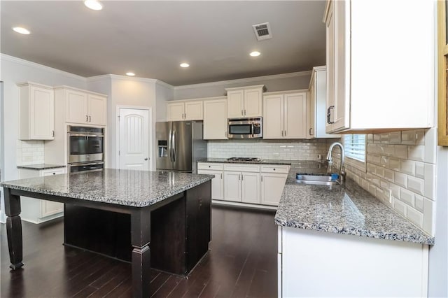 626 Discovery Ct, Acworth, GA 30102 - kitchen featuring crown molding, a sink, stainless steel appliances, stone counters, and a kitchen island