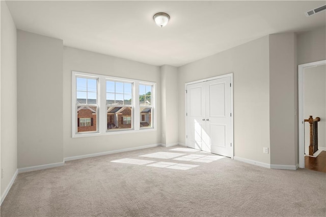 unfurnished bedroom featuring light carpet and a closet