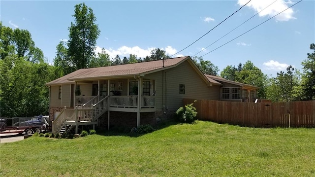 rear view of house with a porch and a yard