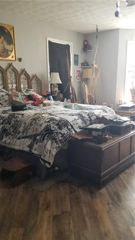 bedroom with a textured ceiling and dark wood-type flooring