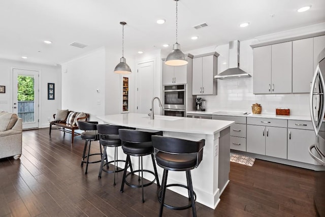 209 Floral Valley Dr, Woodstock, GA 30188 - kitchen featuring wall chimney range hood, a sink, appliances with stainless steel finishes, light countertops, and a breakfast bar area