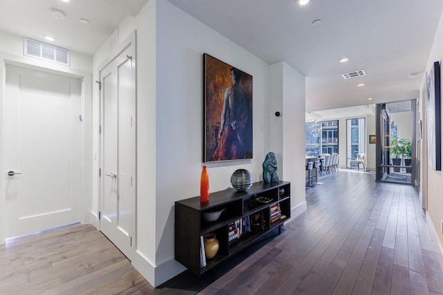 hallway featuring light hardwood / wood-style flooring and a wall of windows