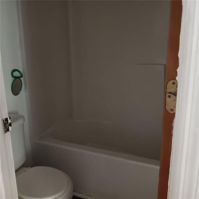 bathroom featuring a tub to relax in and toilet