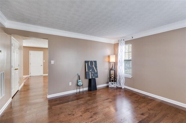 spare room featuring crown molding, dark hardwood / wood-style floors, and a textured ceiling