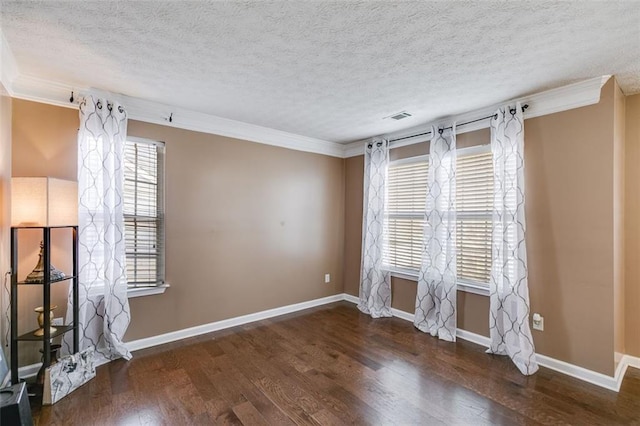 spare room with dark wood-type flooring, ornamental molding, and a textured ceiling