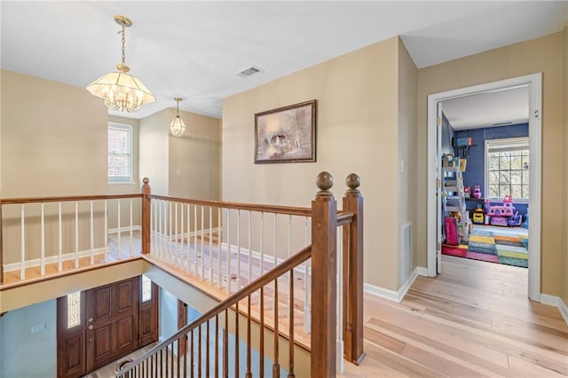 294 Hillcrest Hts, Cornelia, GA 30531 - hall featuring an upstairs landing, light wood-type flooring, a chandelier, and baseboards