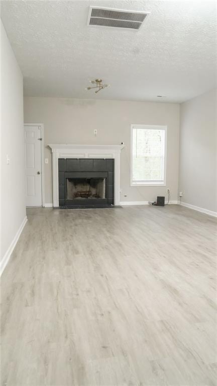 623 Shadowmoore Dr, Riverdale, GA 30274 - unfurnished living room with a fireplace, wood finished floors, and a textured ceiling
