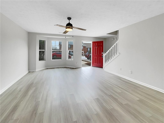 unfurnished living room with a textured ceiling, light hardwood / wood-style flooring, and ceiling fan