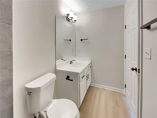 bathroom with hardwood / wood-style floors, vanity, a textured ceiling, and toilet