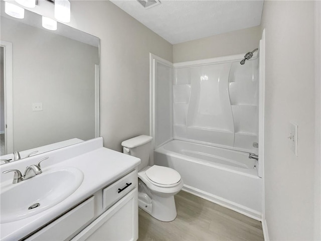 full bathroom with hardwood / wood-style flooring, vanity, bathtub / shower combination, and toilet