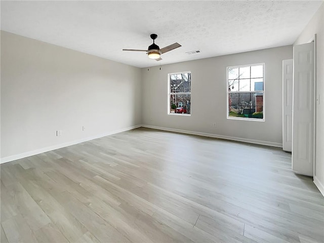 unfurnished room featuring a textured ceiling, light hardwood / wood-style floors, and ceiling fan