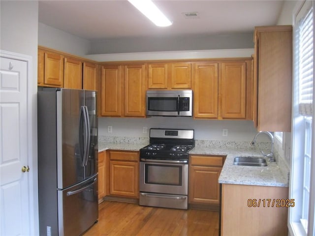 2975 Wintercrest Trce, Dunwoody, GA 30360 - kitchen with appliances with stainless steel finishes, light stone countertops, wood finished floors, and brown cabinetry