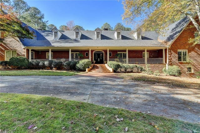 new england style home with a front lawn and a porch