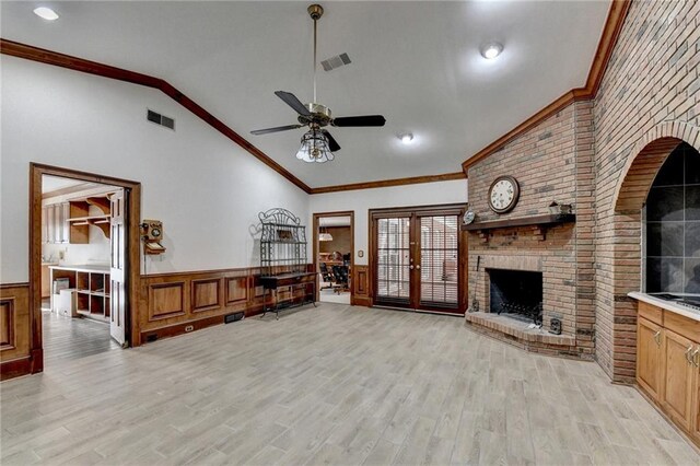 living room with light wood-type flooring, a brick fireplace, ornamental molding, ceiling fan, and lofted ceiling