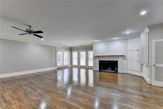 unfurnished living room featuring ceiling fan, dark hardwood / wood-style flooring, and ornamental molding