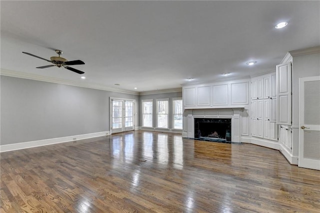 unfurnished living room featuring crown molding, ceiling fan, a premium fireplace, and dark hardwood / wood-style flooring