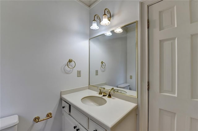 bathroom with vanity, toilet, and crown molding