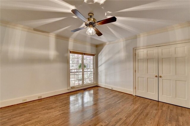 unfurnished bedroom with hardwood / wood-style floors, ceiling fan, and ornamental molding