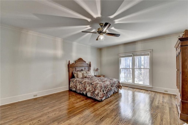 bedroom featuring hardwood / wood-style flooring, ceiling fan, and ornamental molding