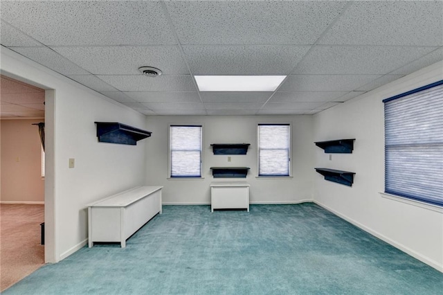 unfurnished living room featuring carpet floors and a paneled ceiling