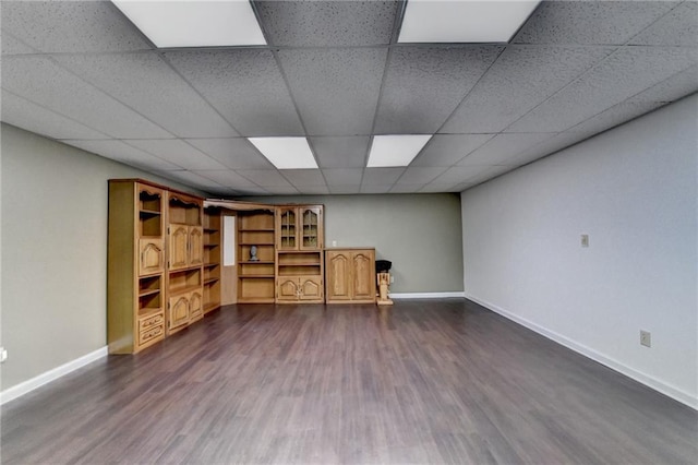 interior space with dark hardwood / wood-style flooring and a drop ceiling