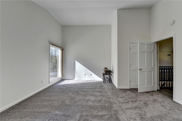 carpeted spare room featuring lofted ceiling