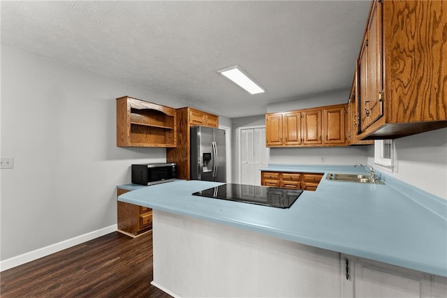 kitchen featuring sink, dark hardwood / wood-style flooring, black appliances, and kitchen peninsula