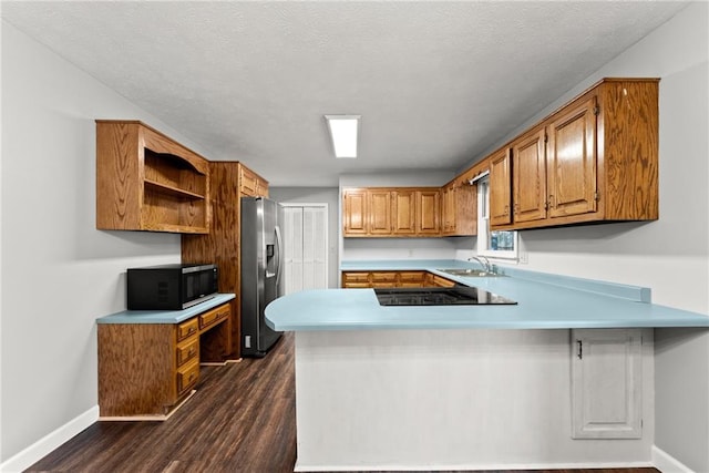 kitchen with kitchen peninsula, stainless steel fridge, black electric stovetop, dark hardwood / wood-style flooring, and sink