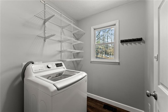 clothes washing area featuring washer / dryer, a textured ceiling, and dark hardwood / wood-style flooring