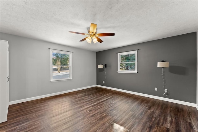 unfurnished room featuring ceiling fan, a wealth of natural light, and dark hardwood / wood-style floors