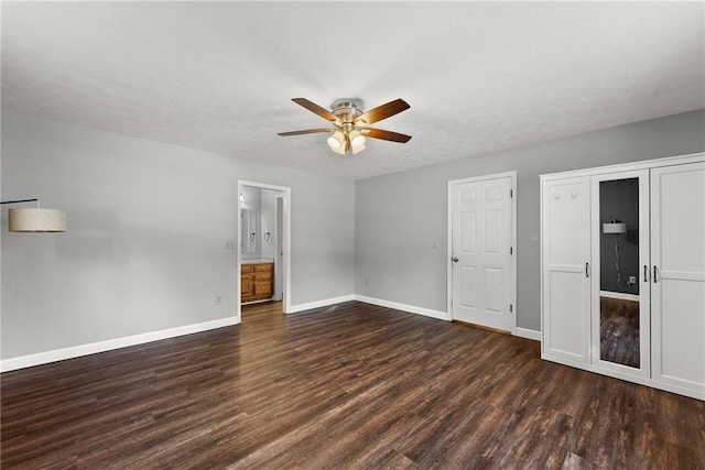 unfurnished bedroom featuring ensuite bath, ceiling fan, and dark hardwood / wood-style floors