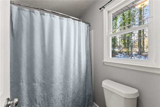 bathroom featuring a textured ceiling and toilet