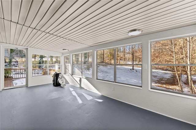 unfurnished sunroom featuring wooden ceiling and a wealth of natural light