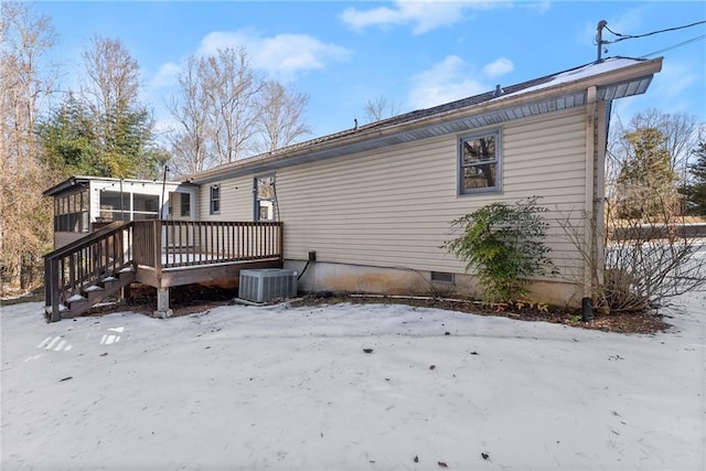 snow covered property featuring a wooden deck, central AC, and a sunroom