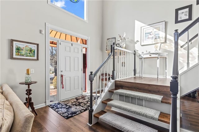 foyer with hardwood / wood-style flooring and a towering ceiling