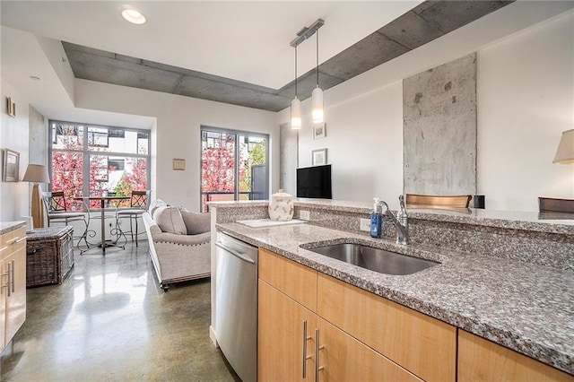 kitchen featuring stainless steel dishwasher, sink, decorative light fixtures, and dark stone countertops