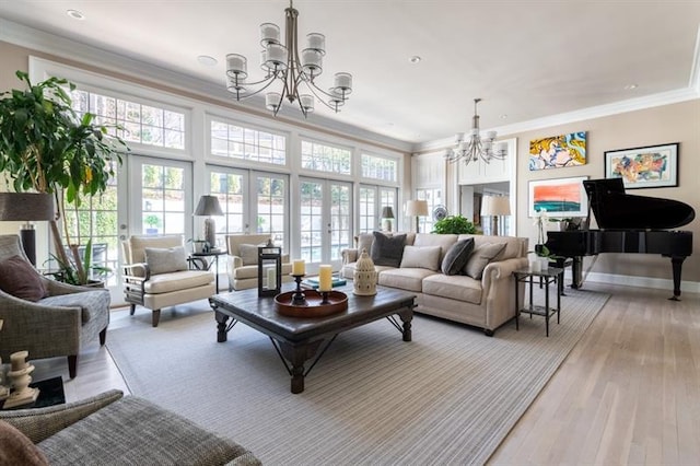 living area featuring crown molding, light wood-style flooring, a notable chandelier, and baseboards