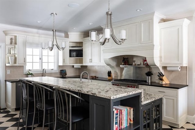 kitchen featuring an island with sink, open shelves, white cabinets, light floors, and a chandelier