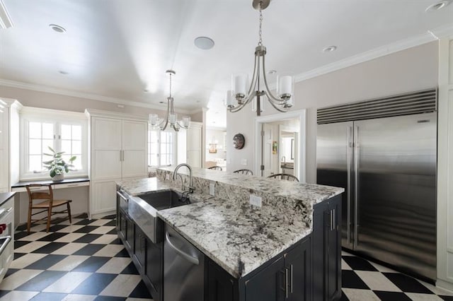 kitchen featuring a notable chandelier, dark cabinets, stainless steel appliances, and dark floors