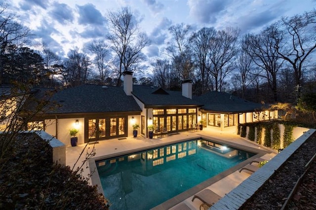 outdoor pool featuring french doors and a patio