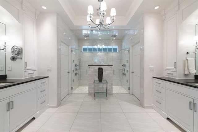 full bath with vanity, a tray ceiling, a stall shower, ornamental molding, and a notable chandelier