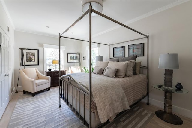 bedroom featuring multiple windows, light wood-type flooring, and ornamental molding