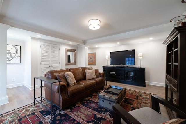 living area with recessed lighting, wood finished floors, baseboards, and ornamental molding