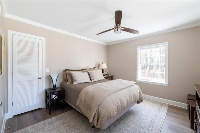 bedroom featuring a ceiling fan, crown molding, wood finished floors, and baseboards