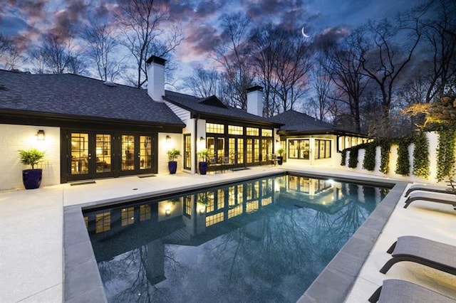 outdoor pool featuring french doors and a patio