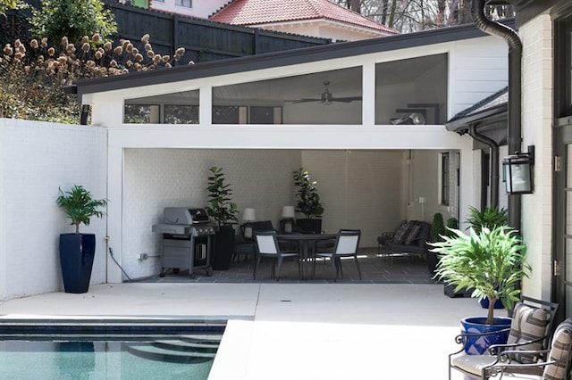 view of patio / terrace with an outdoor pool, a grill, and fence