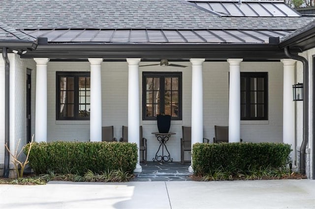 view of exterior entry featuring brick siding, covered porch, and a shingled roof